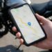 Celular com mapa em frente a uma moto, aplicativo para rastrear moto