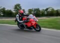 BMW F 450 RR vermelha em curva na pista, com piloto inclinado sobre a esportiva