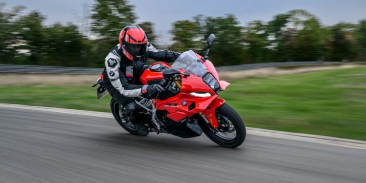 BMW F 450 RR vermelha em curva na pista, com piloto inclinado sobre a esportiva