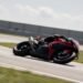 Moto de corrida inclinada em curva de autódromo, calendário MotoGP 2026