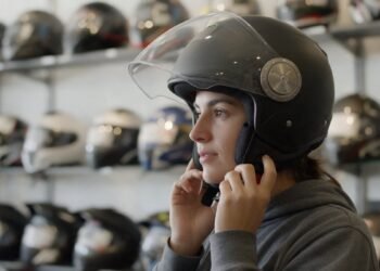 Mulher experimentando capacete com viseira, capacete para chuva e frio