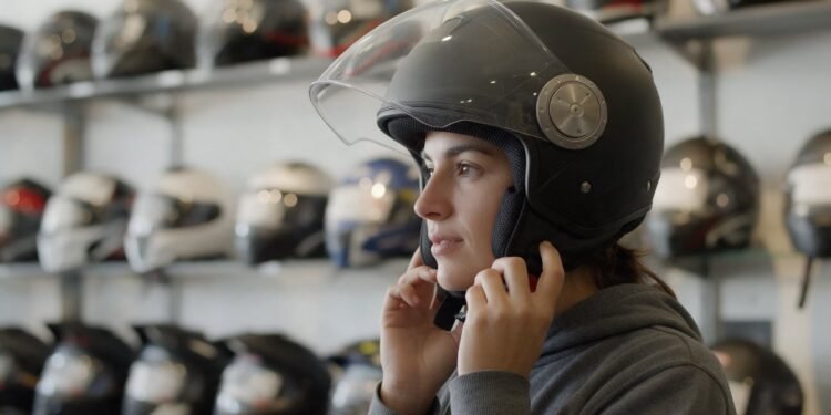Mulher experimentando capacete com viseira, capacete para chuva e frio