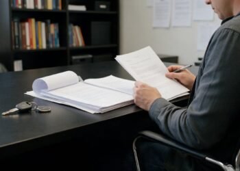 Pessoa lendo contrato com chave de moto na mesa, como cancelar consórcio de moto