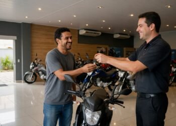 Pessoa recebendo a chave de uma moto nova das mãos de um atendente em uma loja