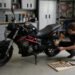 Pessoa fazendo manutenção em garagem, como limpar o filtro de ar da moto