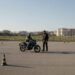 Iniciante pilotando em pátio com cones, como pilotar moto na cidade