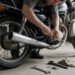 Pessoa trocando peça de moto em garagem, como trocar a vela da moto