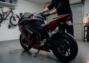 Pessoa secando a moto com um pano na garagem depois da chuva