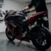 Pessoa secando a moto com um pano na garagem depois da chuva