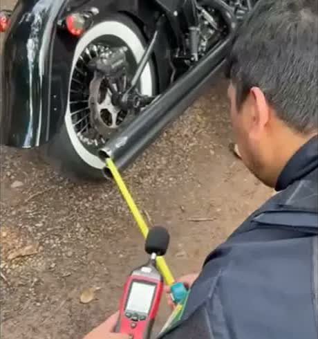 Agente da PRF mede com decibelímetro o ruído do escapamento de uma moto