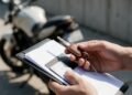 Mãos segurando a chave da moto e uma pasta de documentos