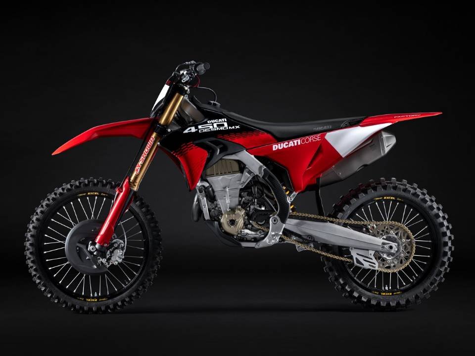 Ducati Desmo450 MX Factory vermelha e preta em vista lateral, com grafismo Ducati Corse