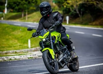 Yamaha MT-03 verde-neon inclinada em uma curva de estrada, pilotada por Eric Vieira