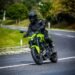 Yamaha MT-03 verde-neon inclinada em uma curva de estrada, pilotada por Eric Vieira