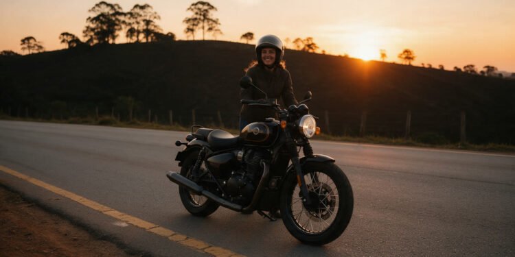 Mulher motociclista sorri ao lado da moto numa estrada ao pôr do sol, para frases de moto feminina