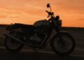 Silhueta de moto parada na estrada ao pôr do sol, cenário para frases de moto para status