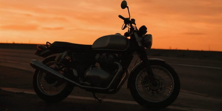 Silhueta de moto parada na estrada ao pôr do sol, cenário para frases de moto para status