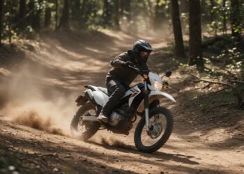 Moto de trilha levantando poeira em uma trilha de terra na floresta