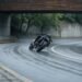 Moto fazendo curva em pista molhada com condução cuidadosa