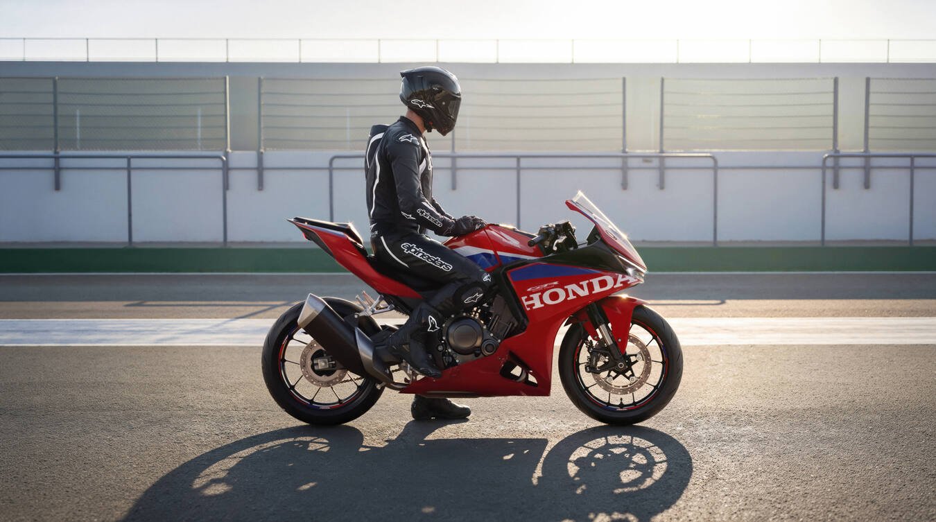 Piloto montado na moto parada no boxe