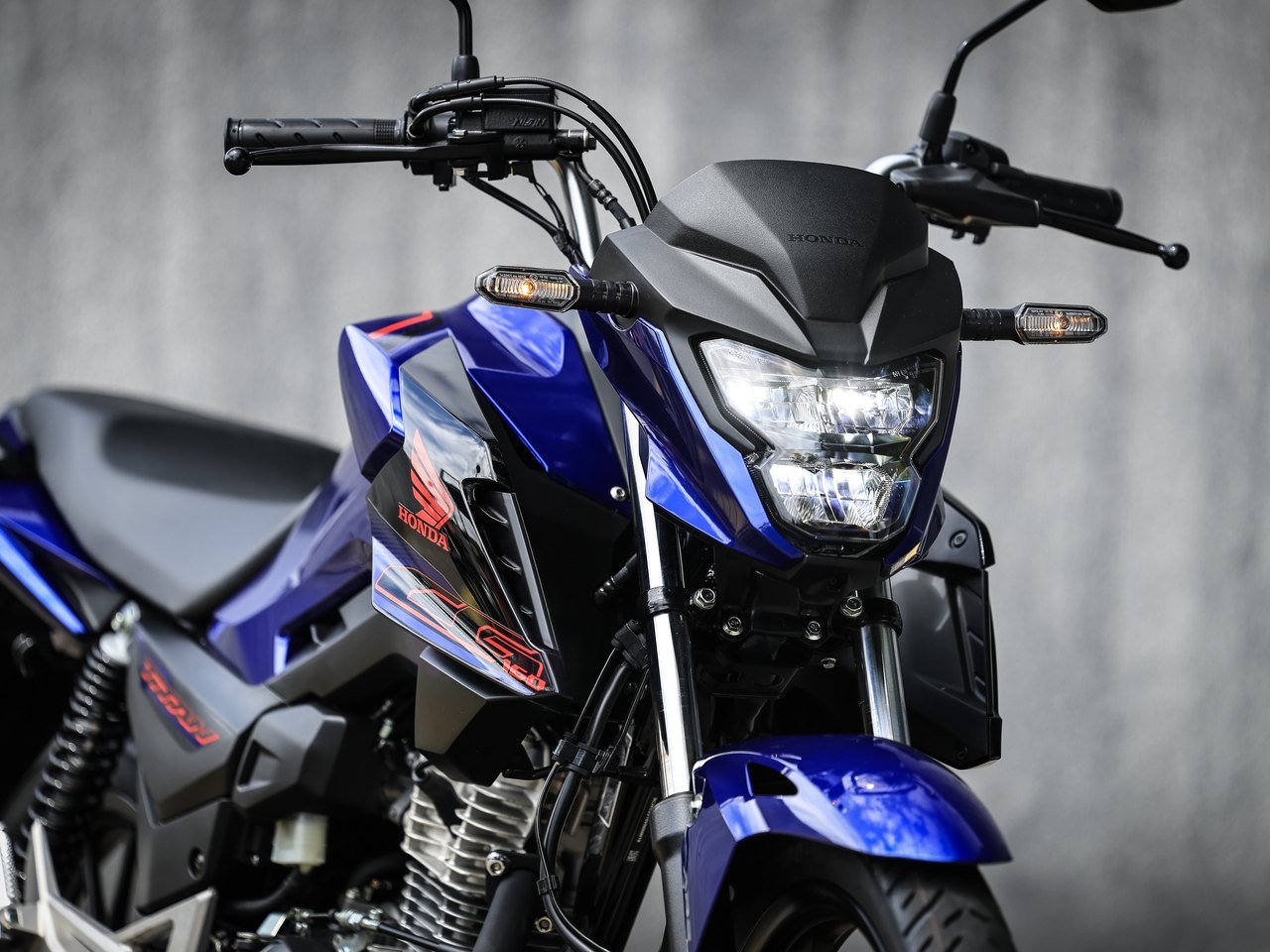 Detalhe do farol de LED e do painel frontal da Honda Titan 2027 azul
