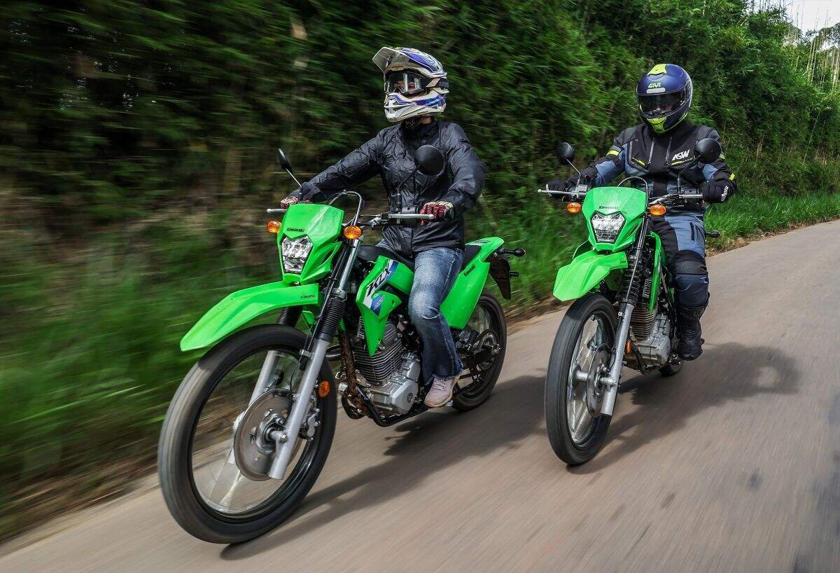 Duas Kawasaki KLX230 verdes rodando em estrada de terra batida, exemplo de trail da marca no Festival Moto Brasil