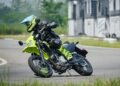 Kawasaki KLX300SM 2027 inclinada em curva em pista de asfalto