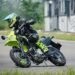 Kawasaki KLX300SM 2027 inclinada em curva em pista de asfalto