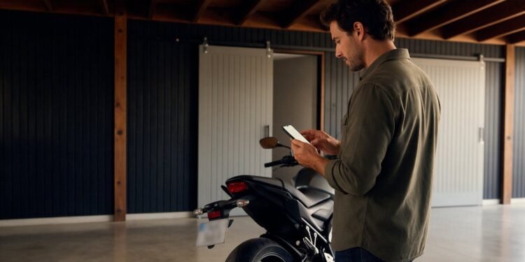 Pessoa usando o celular ao lado da moto para emitir o documento digital