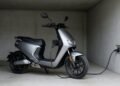 Scooter elétrica carregando, moto elétrica ou a combustão