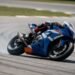 Piloto em moto de corrida azul e branca em curva, onde assistir MotoGP