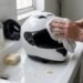 Capacete branco sendo limpo sobre a pia, produto para limpar capacete