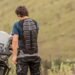 Motociclista de costas usando protetor de costas obrigatório ao lado de moto trail