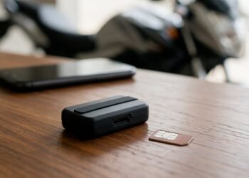 Rastreador e celular sobre mesa, rastreador com ou sem mensalidade