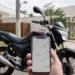 Moto estacionada e mão segurando celular com mapa de localização