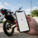 Mão segurando celular com mapa de localização, rastreador de moto em tempo real