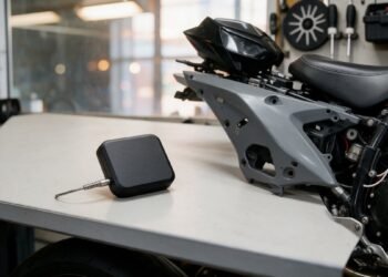Rastreador sobre mesa com moto desmontada ao fundo, rastreador à prova d'água
