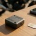 Rastreador, chip e celular sobre mesa de madeira, rastreador para moto sem mensalidade