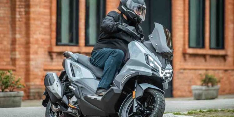 Scooter SYM ADXTG 300 cinza em curva urbana, modelo coberto pela revisão SYM preço fixo