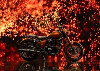 Royal Enfield Classic 650 Hypershift 125th Anniversary Edition de lado, diante de fundo de faíscas alaranjadas