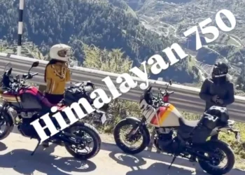 Duas Royal Enfield Himalayan 750 sem camuflagem, uma vermelha e outra branca com grafismos, paradas à beira de estrada de montanha