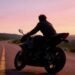 Motociclista em estrada ao pôr do sol, representando a tranquilidade de ter seguro de moto