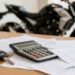 Moto ao fundo com papéis e calculadora, seguro de moto esportiva