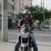 Motorista de aplicativo em cima da moto olhando o celular, representando seguro de moto para aplicativo