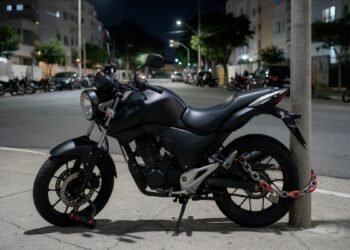 Moto estacionada à noite protegida com trava de disco e corrente contra roubo e furto