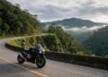 Moto esportiva em estrada de serra com motociclista, seguro de moto Tokio Marine
