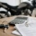 Papéis e calculadora para fazer a simulação de seguro de moto