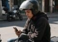 Financiamento de moto simulação feita no celular por uma pessoa de capacete com a moto ao fundo