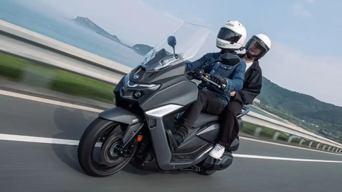 Scooter SYM Maxsym 400 GT em movimento com piloto e garupa, usada para ilustrar o plano de revisão com preço fixo