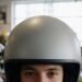 Pessoa experimentando capacete em loja de equipamentos, tipos de capacete de moto